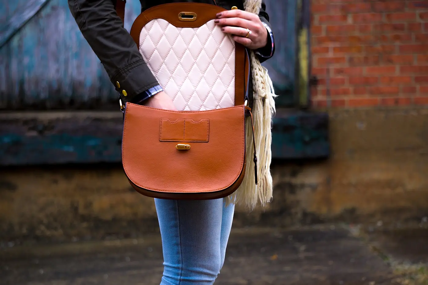 Femme qui ouvre un sac selle en cuir cognac